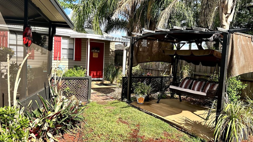 Pergola swing and lush garden alongside the grooming shed